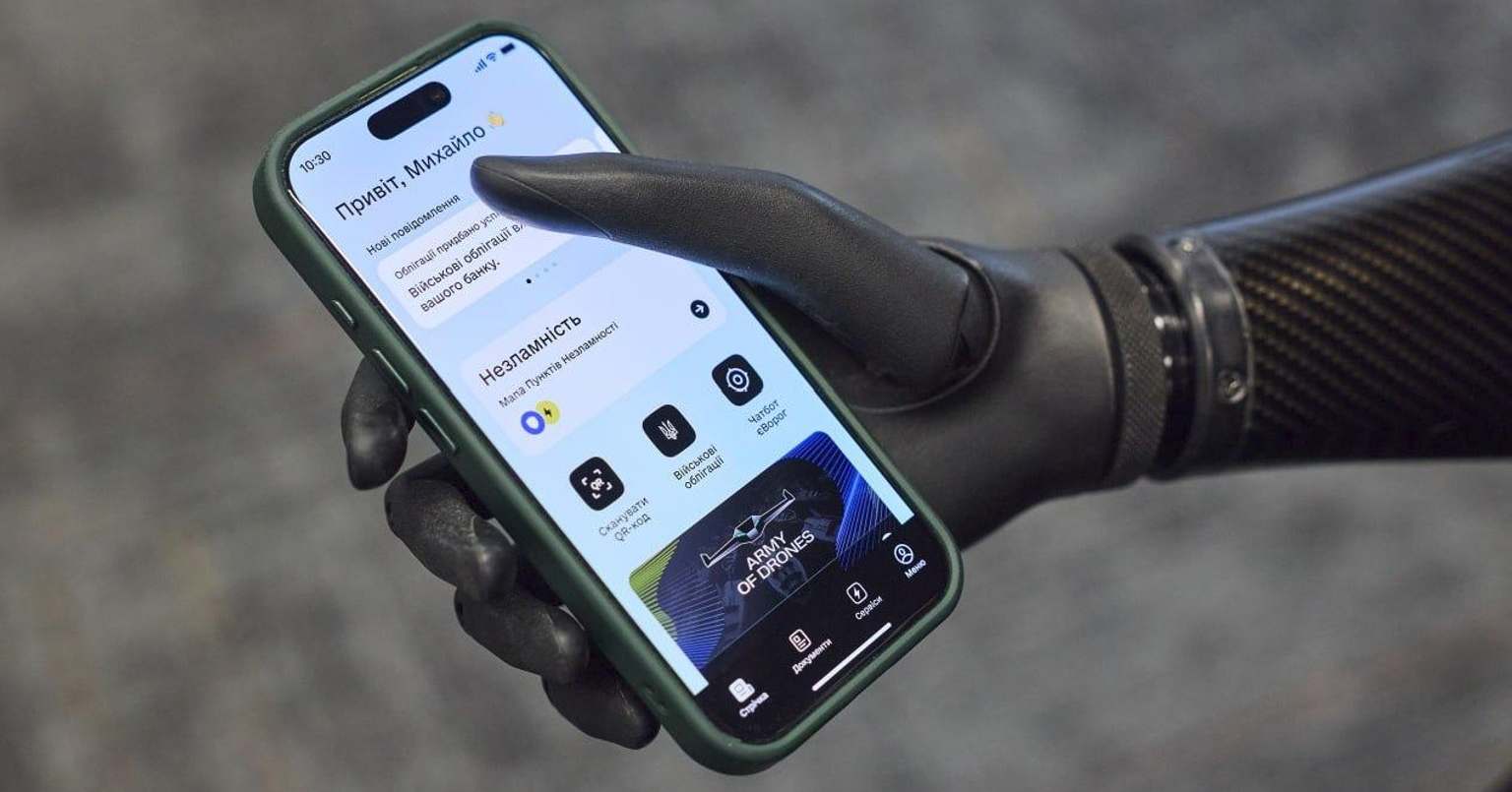 Людина з протезом руки користується мобільним застосунком на смартфоні