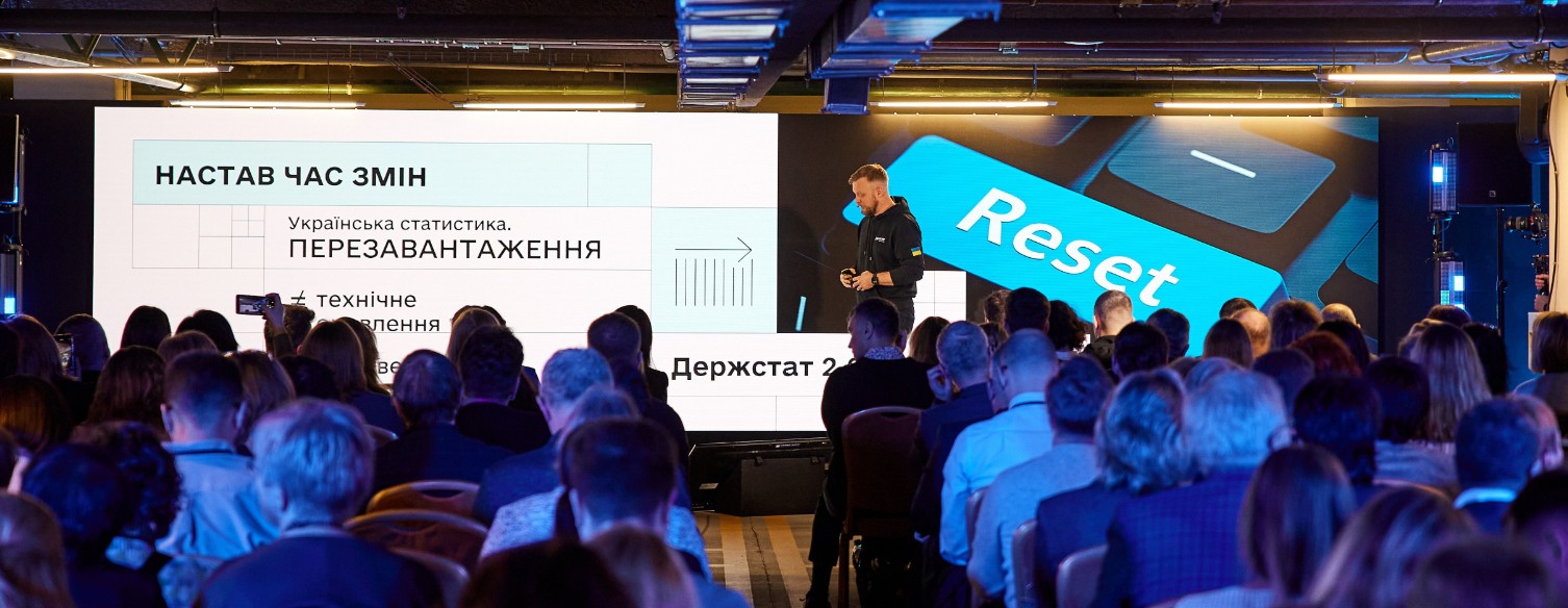 Презентація нового порталу Держстату з вбудованим ШІ-асистентом StatGPT. На екрані напис «Українська статистика. Перезавантаження» та зображення клавіші «Reset». Перед сценою сидить аудиторія.