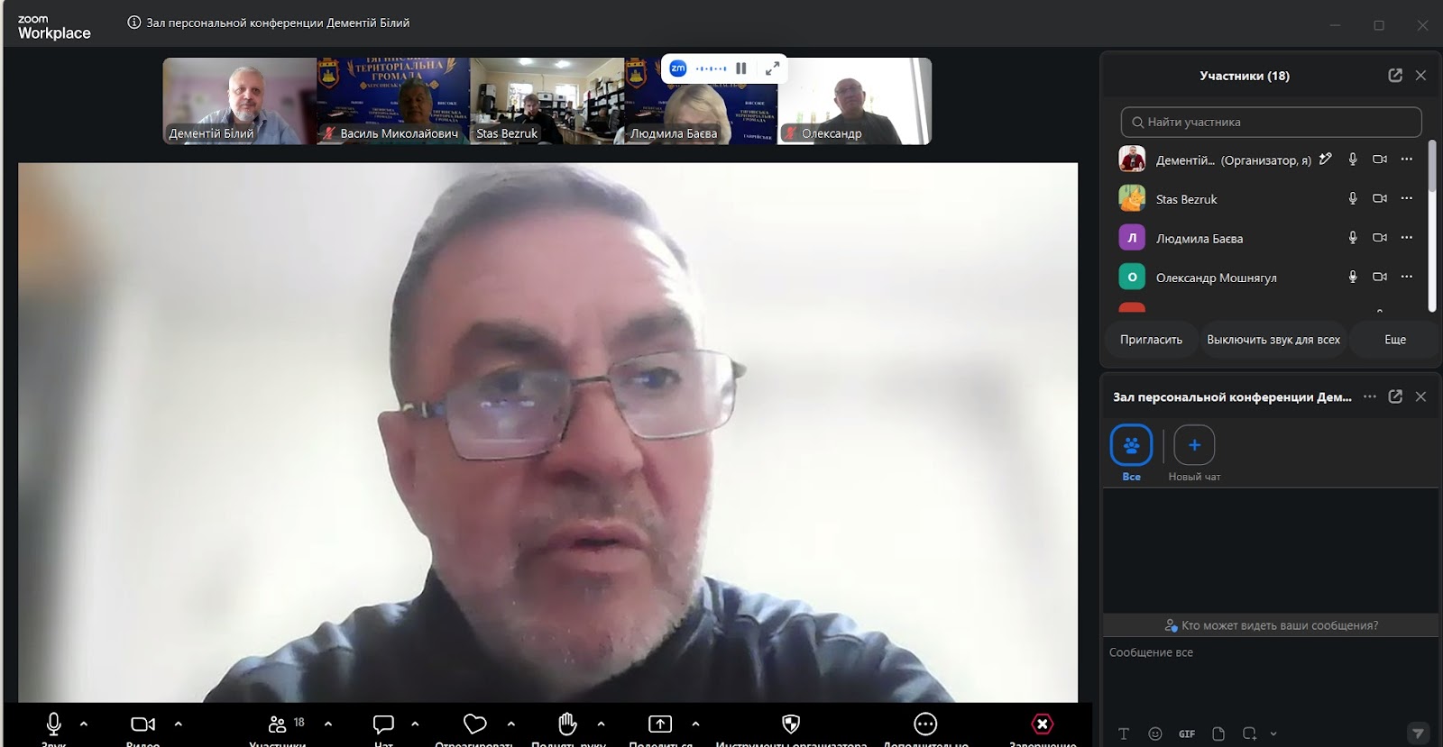 Скриншот дистанційної наради Zoom під час виступу Людмили Баєвої, яка говорить на камеру крупним планом. Позаду неї встановлено темно-синій брендований банер Тягинської територіальної громади Херсонської області з офіційним гербом, колосками та назвами сіл (Тягинка, Львове, Високе, Ольгівка, Бургунка). У верхній стрічці видно віконця інших підключених учасників, праворуч відкрито бічну панель зустрічі.