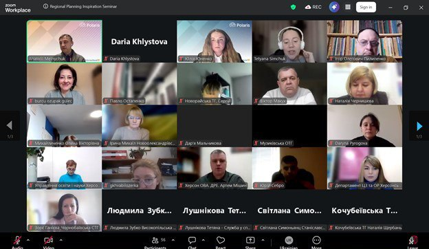 Скриншот вікна відеоконференції з сіткою учасників. Відображено багато віконець із відеозв'язком та окремі плитки з іменами на чорному тлі.