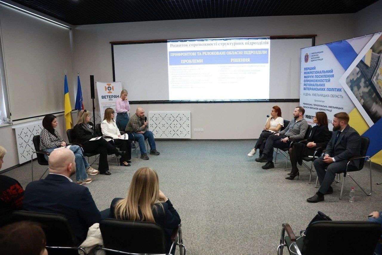 Учасники обговорюють ветеранську політику під час форуму в Хмельницькому. У залі встановлено тематичні банери та проєкційний екран із презентацією про розвиток спроможності прифронтових і релокованих підрозділів.