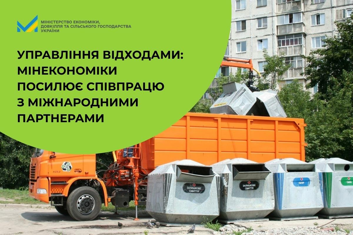 Помаранчевий сміттєвоз завантажує контейнери для сортування відходів біля багатоповерхівки. На зеленому фоні — напис про міжнародну співпрацю Мінекономіки в управлінні відходами.