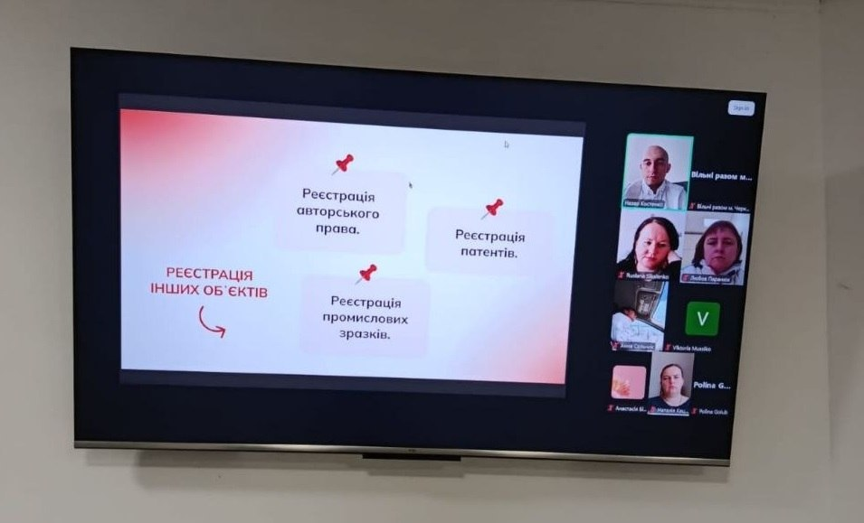 На екрані телевізора відображено вікно онлайн-конференції. Ліворуч — слайд презентації про реєстрацію авторського права, патентів та промислових зразків. Праворуч видно вікна з учасниками відеозустрічі.