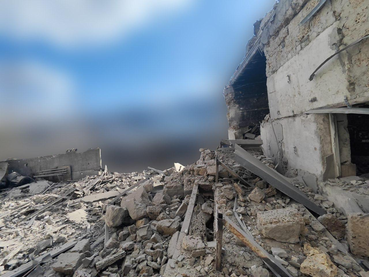 Наслідки влучання: повністю зруйнована капітальна будівля. На передньому плані — купи будівельного каміння, залізобетонних уламків та металевих конструкцій під відкритим небом.