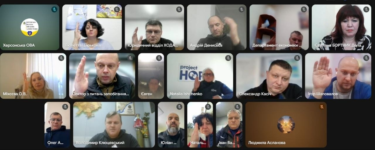 Скриншот онлайн-конференції в Google Meet із сіткою учасників. Кілька людей тримають підняті руки, наче під час голосування або обговорення. У вікнах відображаються назви різних відомств та організацій.