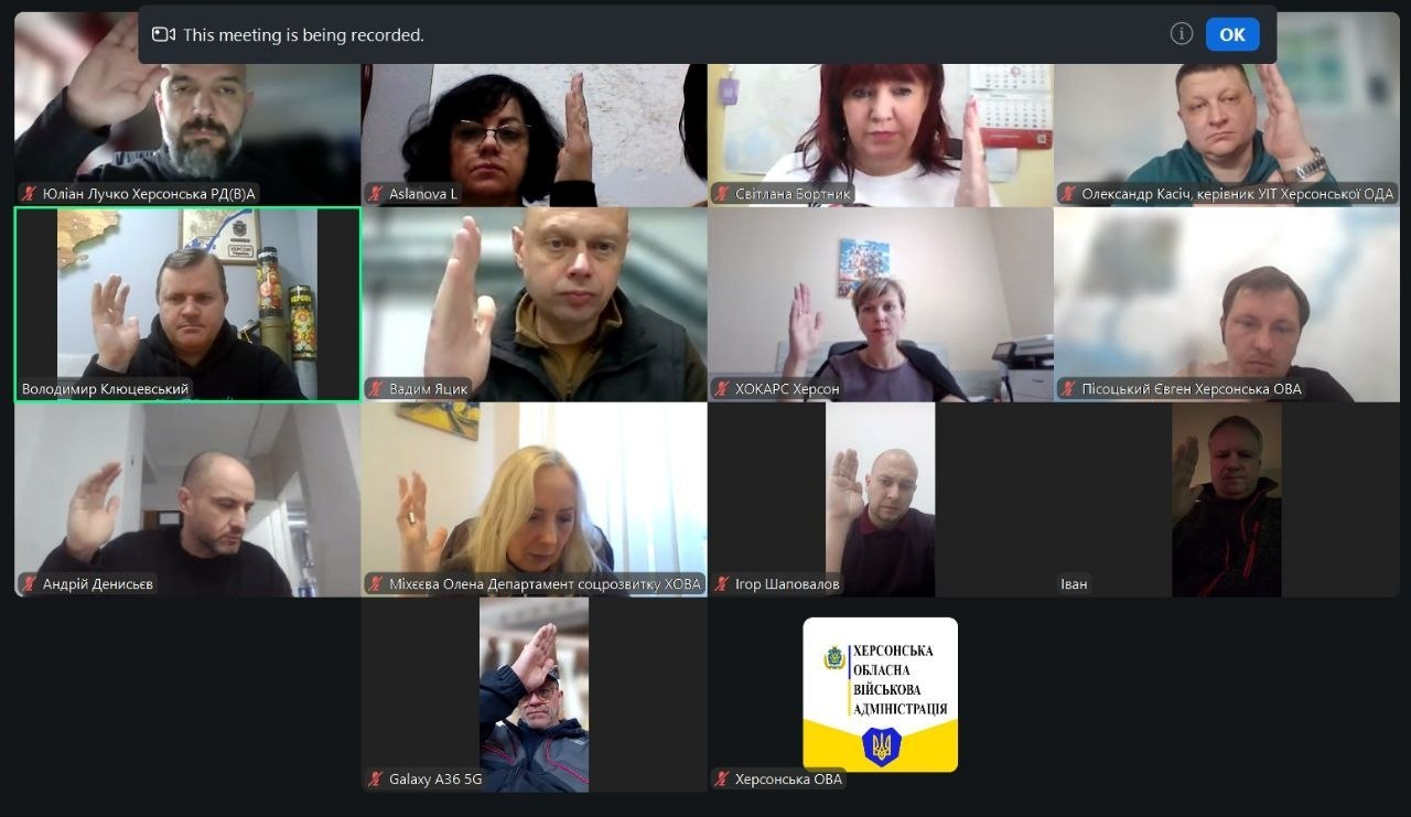 Скриншот онлайн-наради у форматі відеоконференції, де учасники одночасно піднімають руки для голосування. На екрані відображаються вікна з відеотрансляціями та вікно з логотипом Херсонської обласної військової адміністрації.