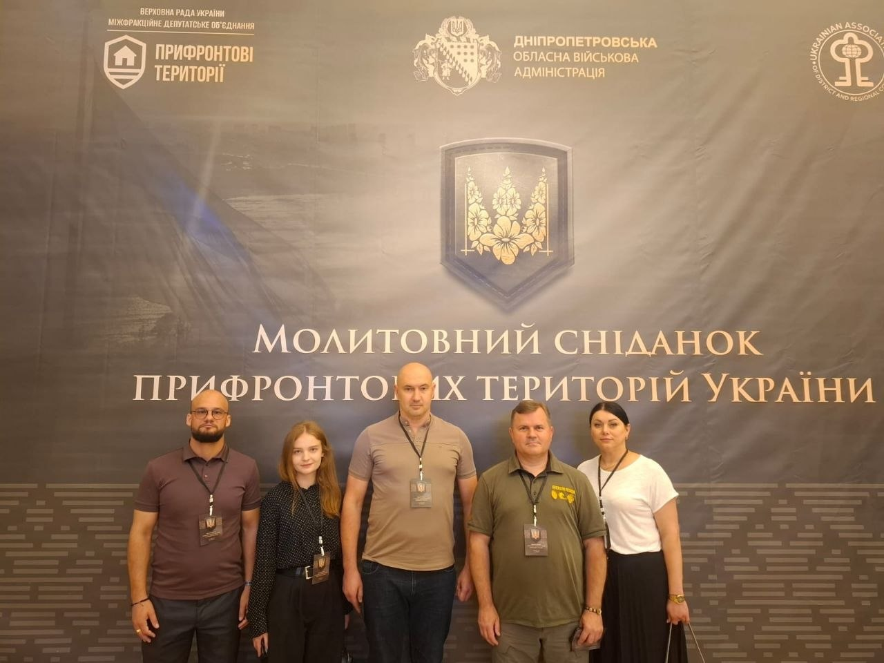 П'ять людей стоять на тлі офіційного банера з написами «Молитовний сніданок прифронтових територій України» та логотипами організаторів.