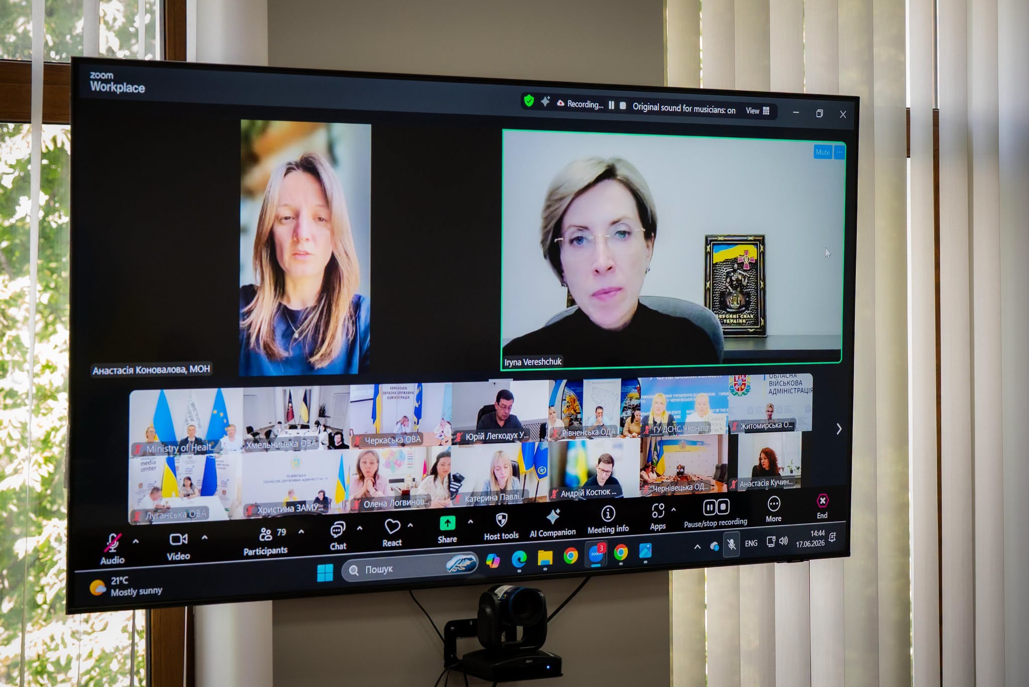 Екран монітора, на якому відображається онлайн-нарада у Zoom Workplace з великою кількістю учасників у форматі відеоконференції.