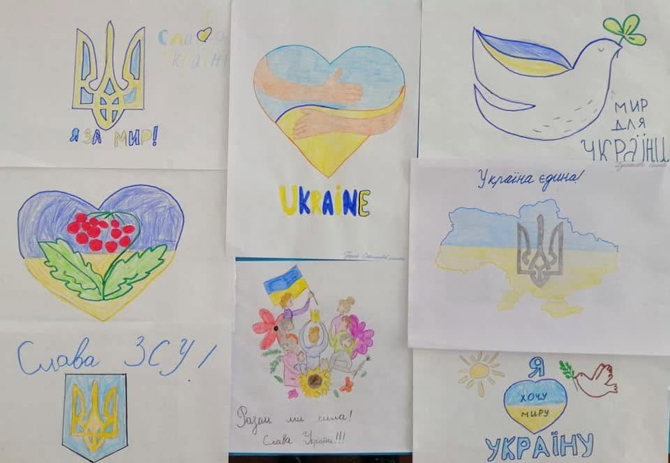 Колекція дитячих патріотичних малюнків на білих аркушах паперу. На них зображено герб України, синьо-жовті серця, голуба миру, карту країни та гілку калини з написами «Слава ЗСУ!», «Україна єдина!» та «Я за мир!».