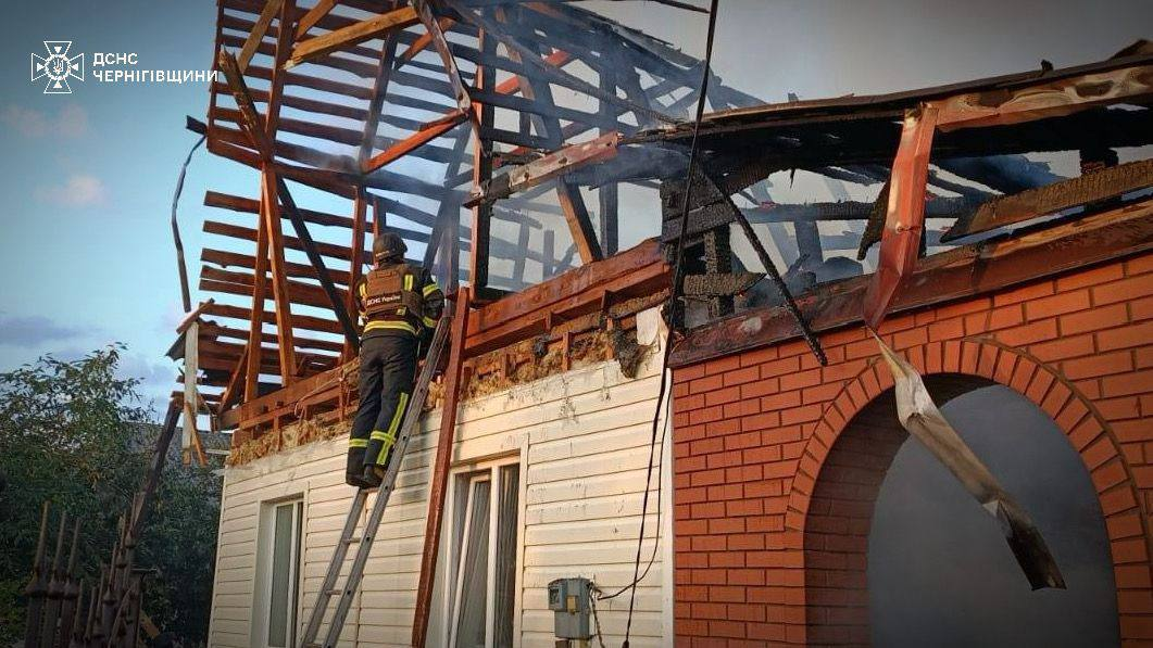 Рятувальник по драбині піднімається на повністю зруйнований та обгорілий дах цегляного будинку, від якого йде легкий дим. У лівому верхньому кутку розміщено емблему з написом «ДСНС ЧЕРНІГІВЩИНИ».