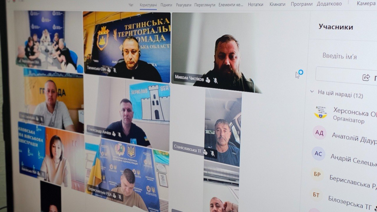 Скріншот екрана з вікнами учасників онлайн-наради, деякі з яких перебувають на тлі офіційних банерів територіальних громад, та бічною панеллю зі списком присутніх.