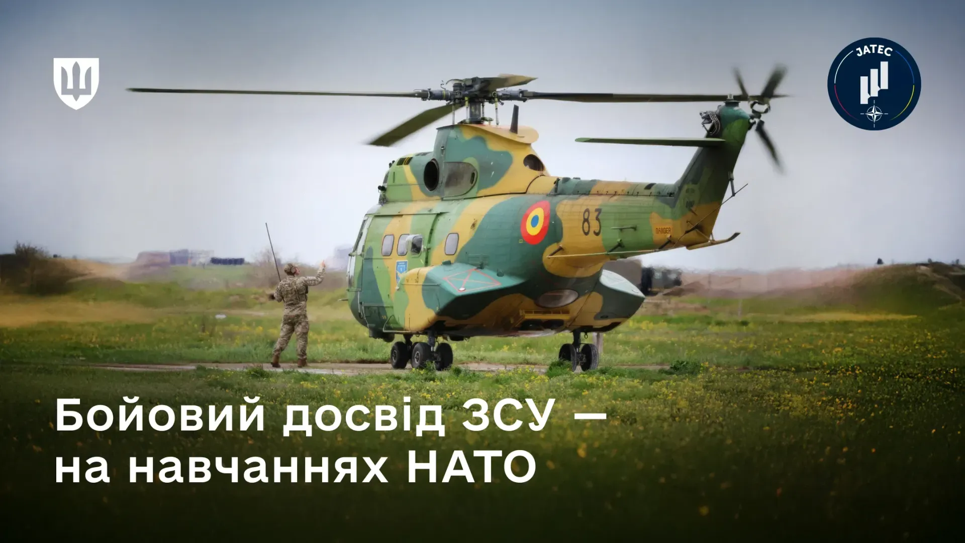 Військовий вертоліт у камуфляжі стоїть на полі, а поруч із ним перебуває військовослужбовець, який подає сигнальні знаки. Поверх зображення нанесено напис «Бойовий досвід ЗСУ — на навчаннях НАТО» та логотипи у верхніх кутах.