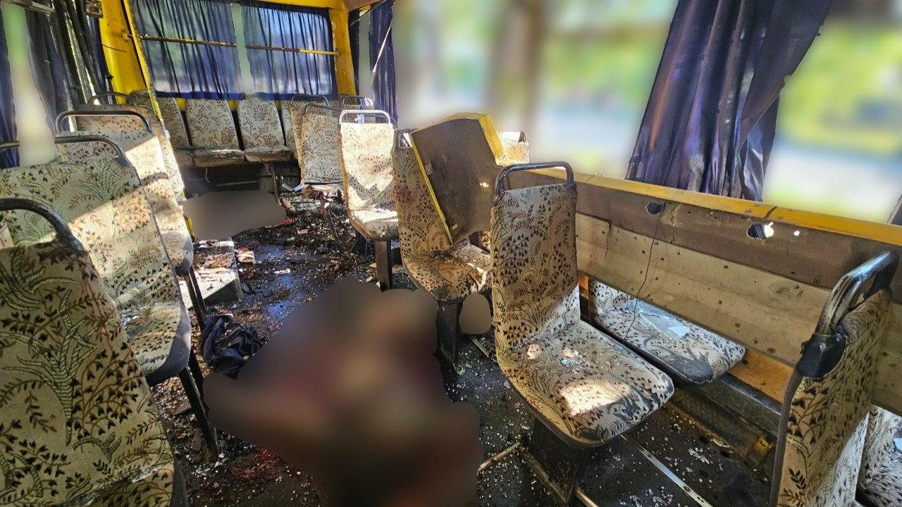 Понівечений усередині салон пасажирського автобуса із розбитими сидіннями, уламками скла та розкиданими речами на підлозі.