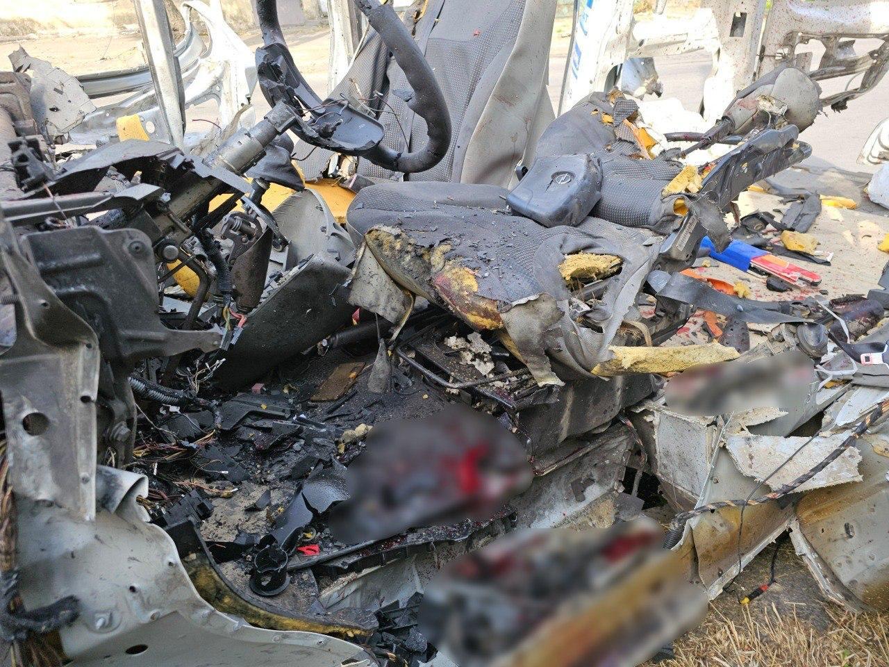 Повністю знищений та деформований салон автомобіля зсередини після масштабної аварії. Переднє сидіння розірване, кермо зміщене, панель приладів розтрощена, а окремі зони на підлозі та сидінні замилені для приховання чутливих деталей.