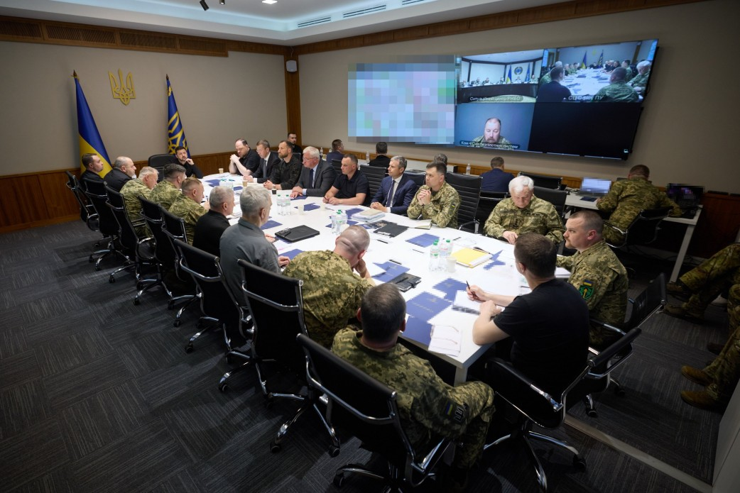 Спеціальне засідання Ставки Верховного Головнокомандувача під головуванням Президента України. Військове та політичне керівництво сидить за великим столом у залі нарад із документами та екранами відеозв'язку.