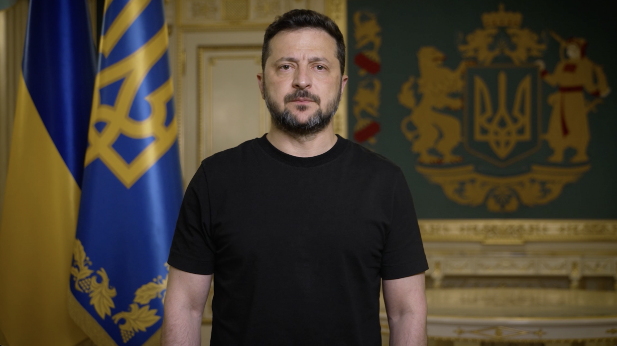 Президент України Володимир Зеленський під час офіційного звернення на тлі державної символіки.
