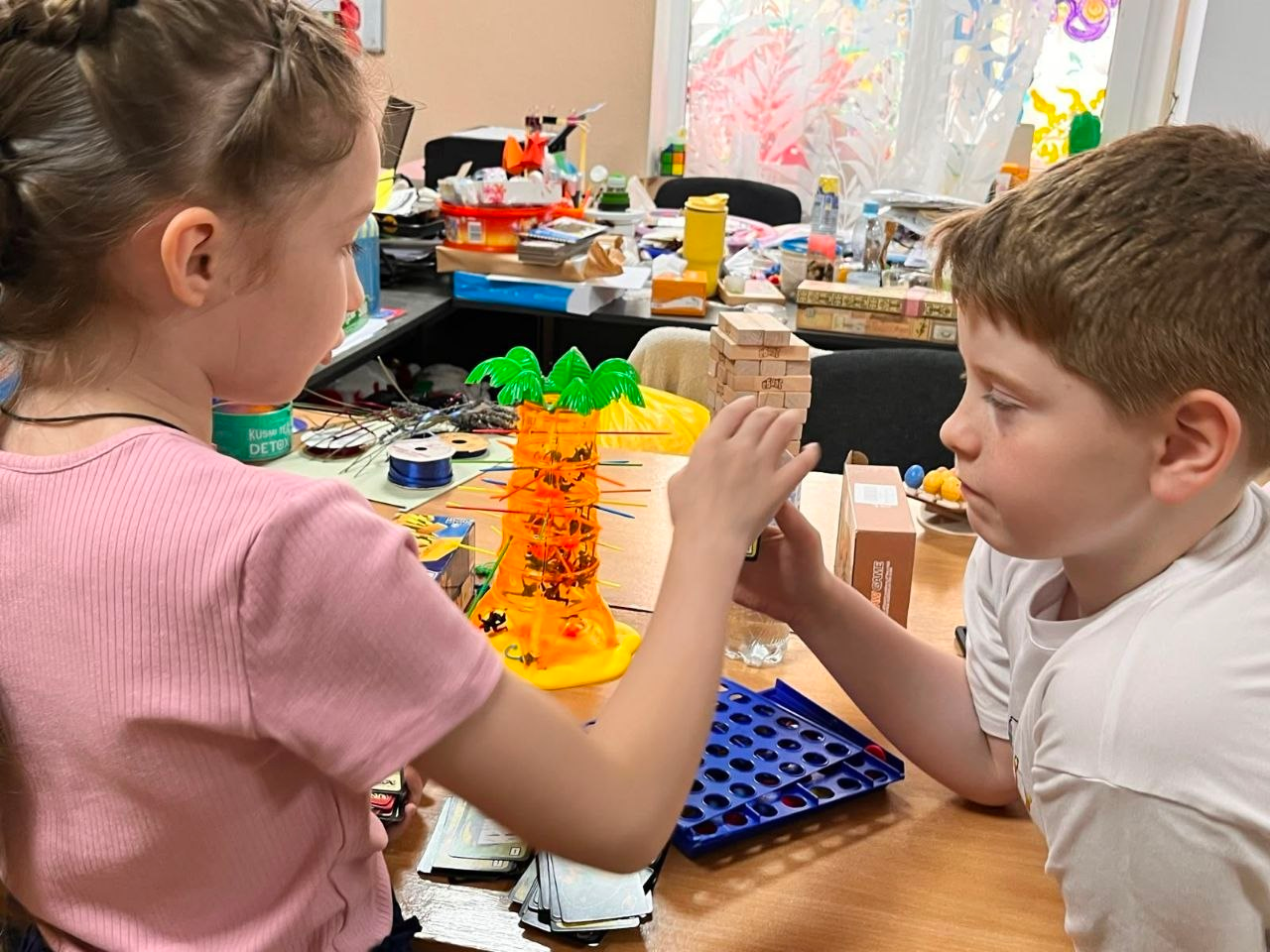 Двоє дітей з родин ВПО з Херсонщини грають у настільні ігри під час дозвілля в дитячому просторі у Миколаєві.