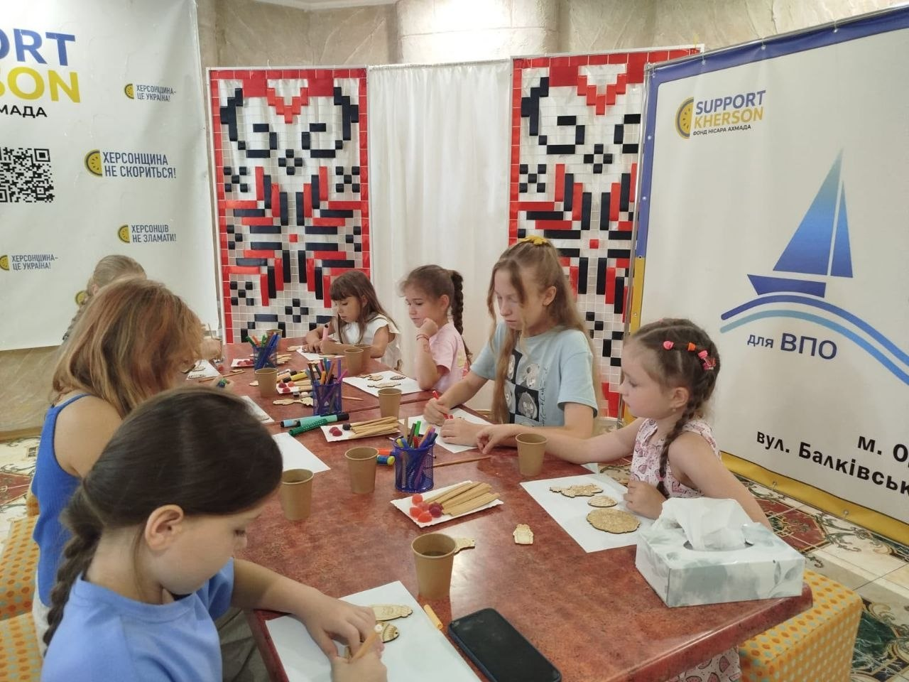 Діти з родин ВПО у координаційному центрі «Вільні разом» в Одесі займаються розфарбовуванням дерев’яних та гіпсових фігурок під час майстер-класу.