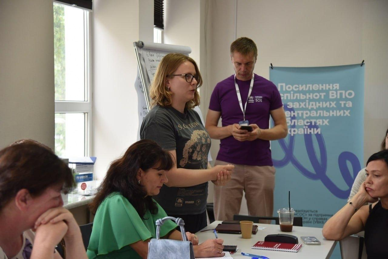 Учасники тренінгу з посилення спільнот ВПО від «Крим SOS» слухають виступ спікерки, яка розповідає про можливості працевлаштування, навчання, перекваліфікації та грантові програми від центру зайнятості.