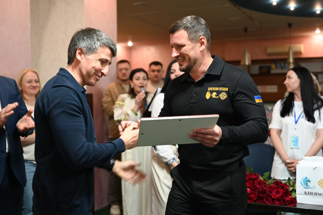 Начальник Херсонської ОВА Олександр Прокудін тисне руку та вручає подяку в рамці голові Закарпатської ОДА Мирославу Білецькому (ліворуч) під час офіційного відкриття осередку підтримки для жителів Херсонщини в Ужгороді.