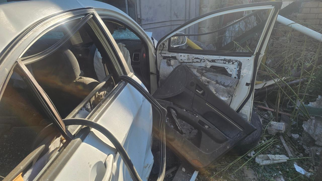 Понівечений вибухом легковий автомобіль у Херсоні з вибитими шибками, деформованим кузовом, зірваною внутрішньою обшивкою та відчиненими пошкодженими дверима.