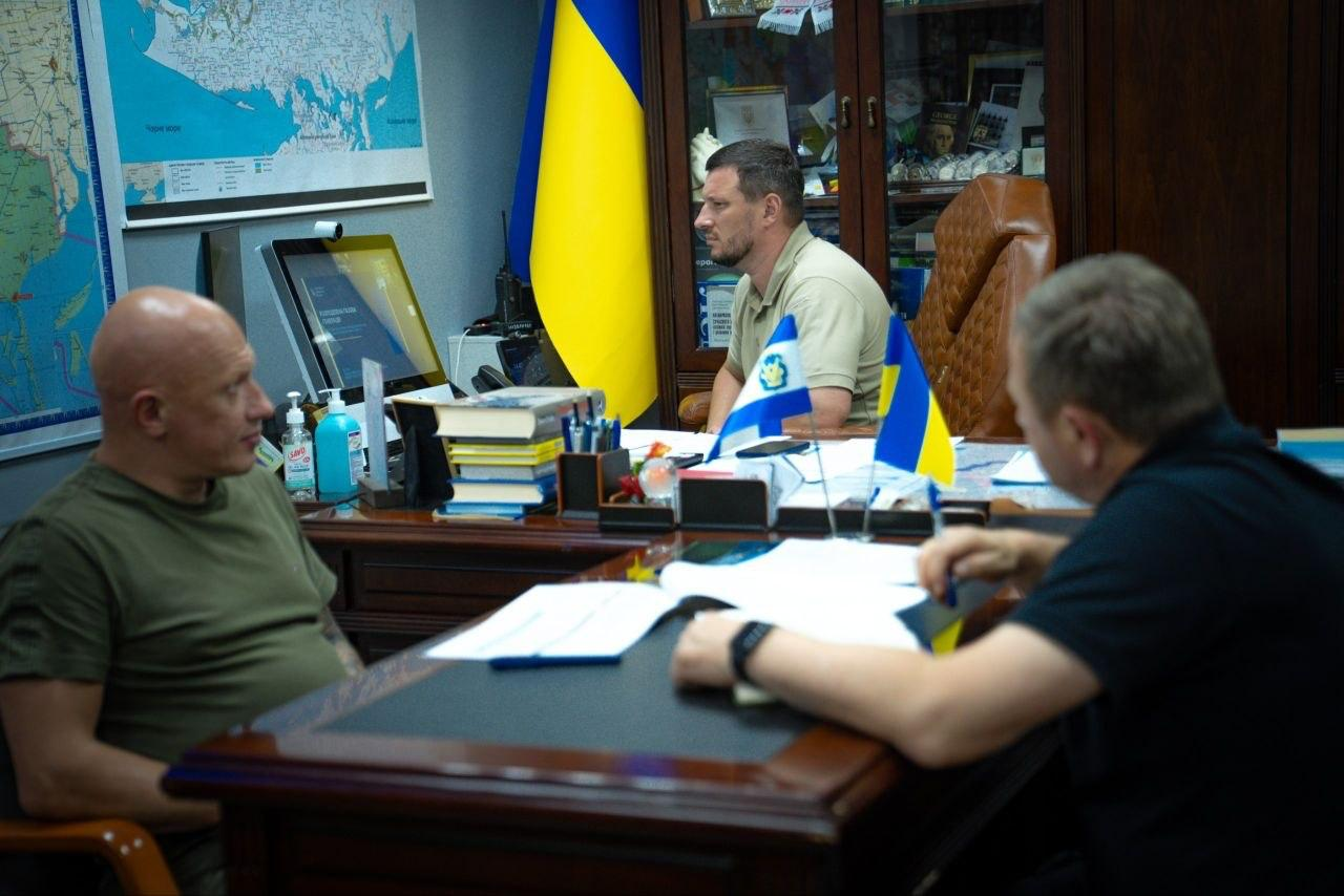 Начальник Херсонської ОВА Олександр Прокудін за робочим столом бере участь у засіданні Координаційного штабу з питань реалізації комплексних планів стійкості регіонів, захисту критичної інфраструктури та розвитку розподіленої генерації, де на передньому плані ліворуч сидить заступник начальника ОВА Євгеній Ігнатенко, а праворуч — перший заступник начальника ОВА Дмитро Бутрій.