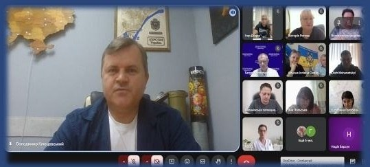 Скриншот онлайн-наради щодо реалізації проєктів коштом державних субвенцій у деокупованих громадах. У великому вікні ліворуч виступає заступник голови Херсонської ОДА Володимир Клюцевський на тлі мапи України та емблеми Херсона. Праворуч у сітці відеотрансляцій розміщені віконця інших учасників зустрічі, серед яких представники управління освіти і науки ХОДА та начальники місцевих адміністрацій Херсонського і Бериславського районів.