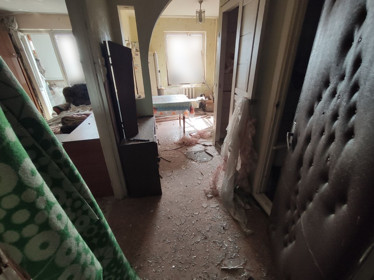 Понівечений коридор та житлові кімнати квартири в Центральному районі Херсона, всіяні уламками скла та сміттям після нічного влучання російського БпЛА у багатоповерхівку.