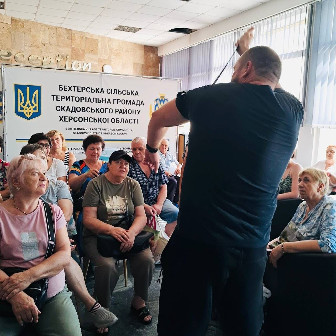 Інструктор Сил спеціальних операцій проводить заняття з тактичної медицини для переселенців Бехтерської громади Херсонщини, демонструючи накладання турнікета на руку.