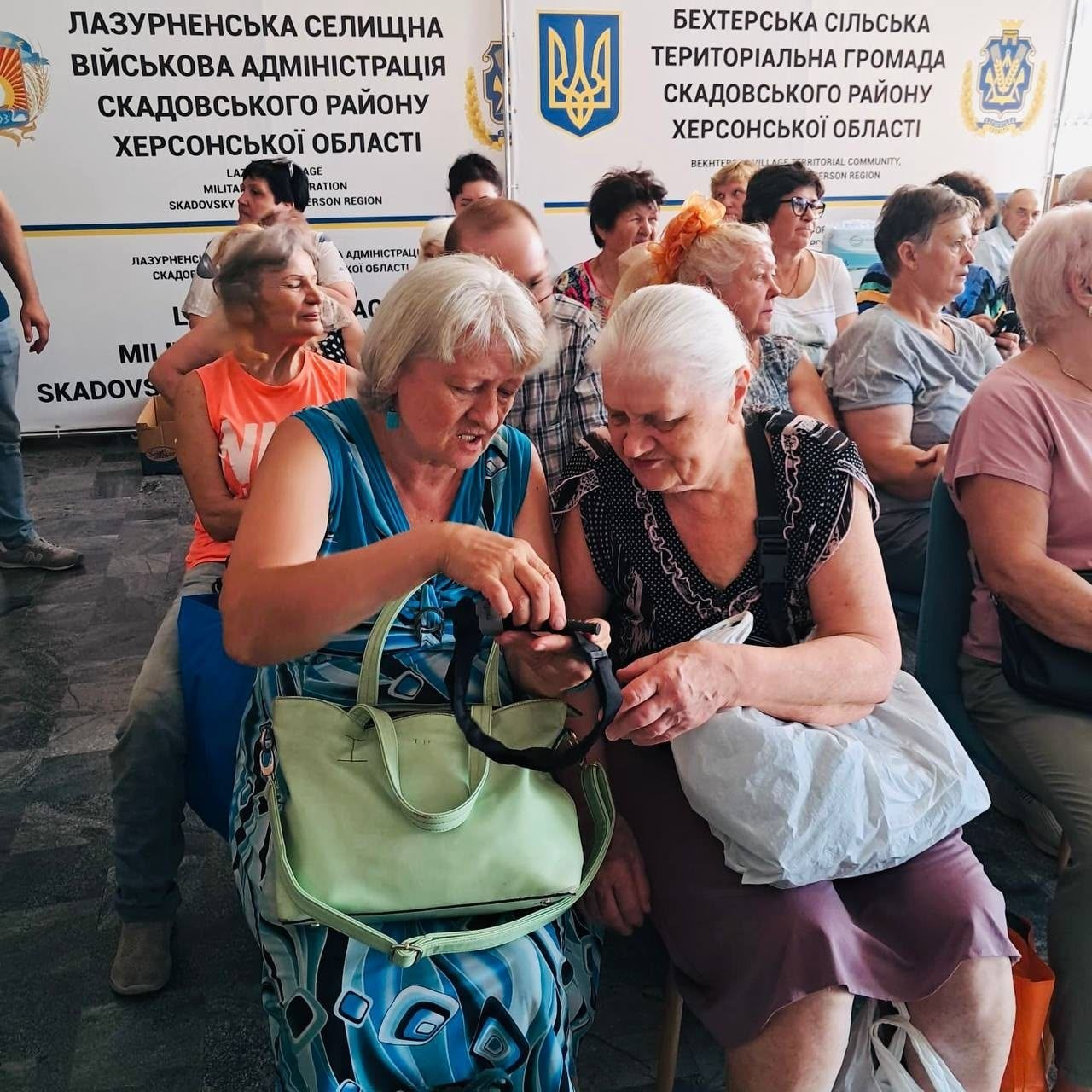 Переселенки з Херсонщини на практичному занятті з тактичної медицини спільно вчаться правильно тримати та налаштовувати медичний турнікет.