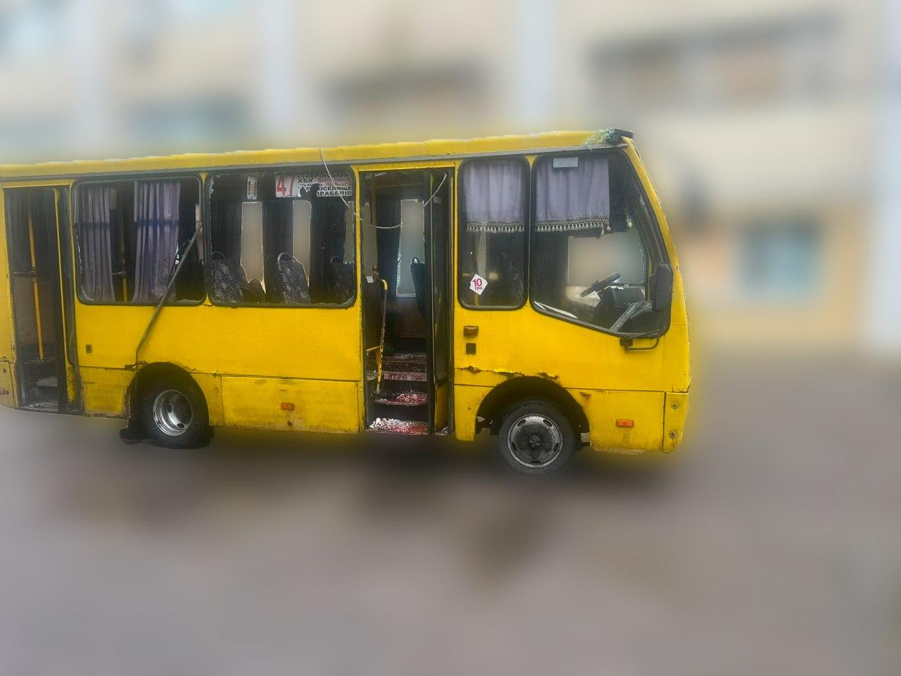 Жовтий міський автобус у Херсоні, пошкоджений внаслідок удару російським дроном. Вигляд з іншого ракурсу: у транспортного засобу повністю вибиті бічні шибки та частково розбите лобове скло. Передні пасажирські двері відчинені, на сходах та всередині салону видно уламки. На вікні розміщено трафарет міського маршруту №47.