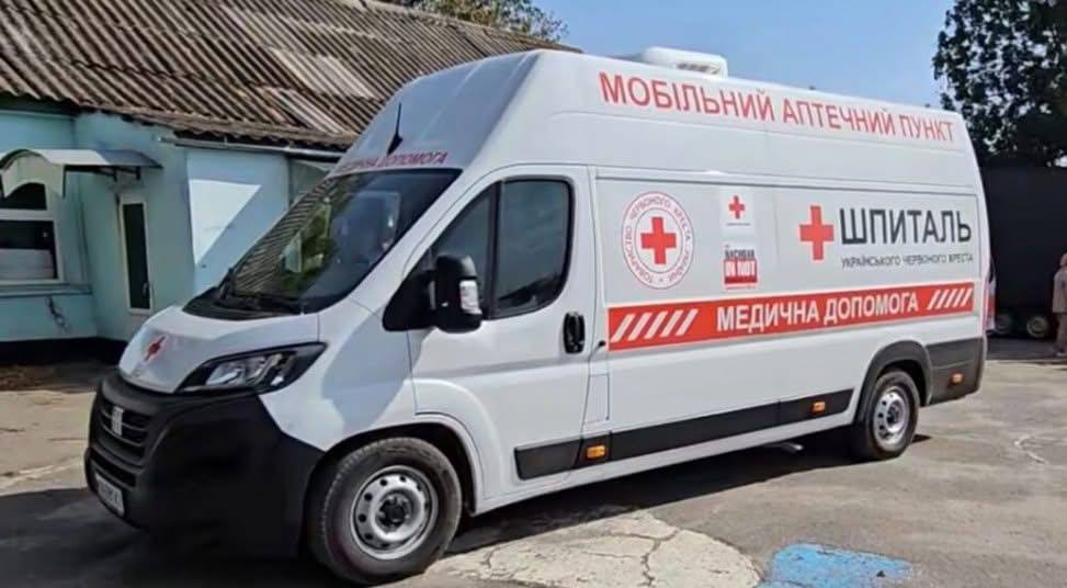 Білий фургон мобільного аптечного пункту з емблемами Червоного Хреста та написом «Медична допомога».