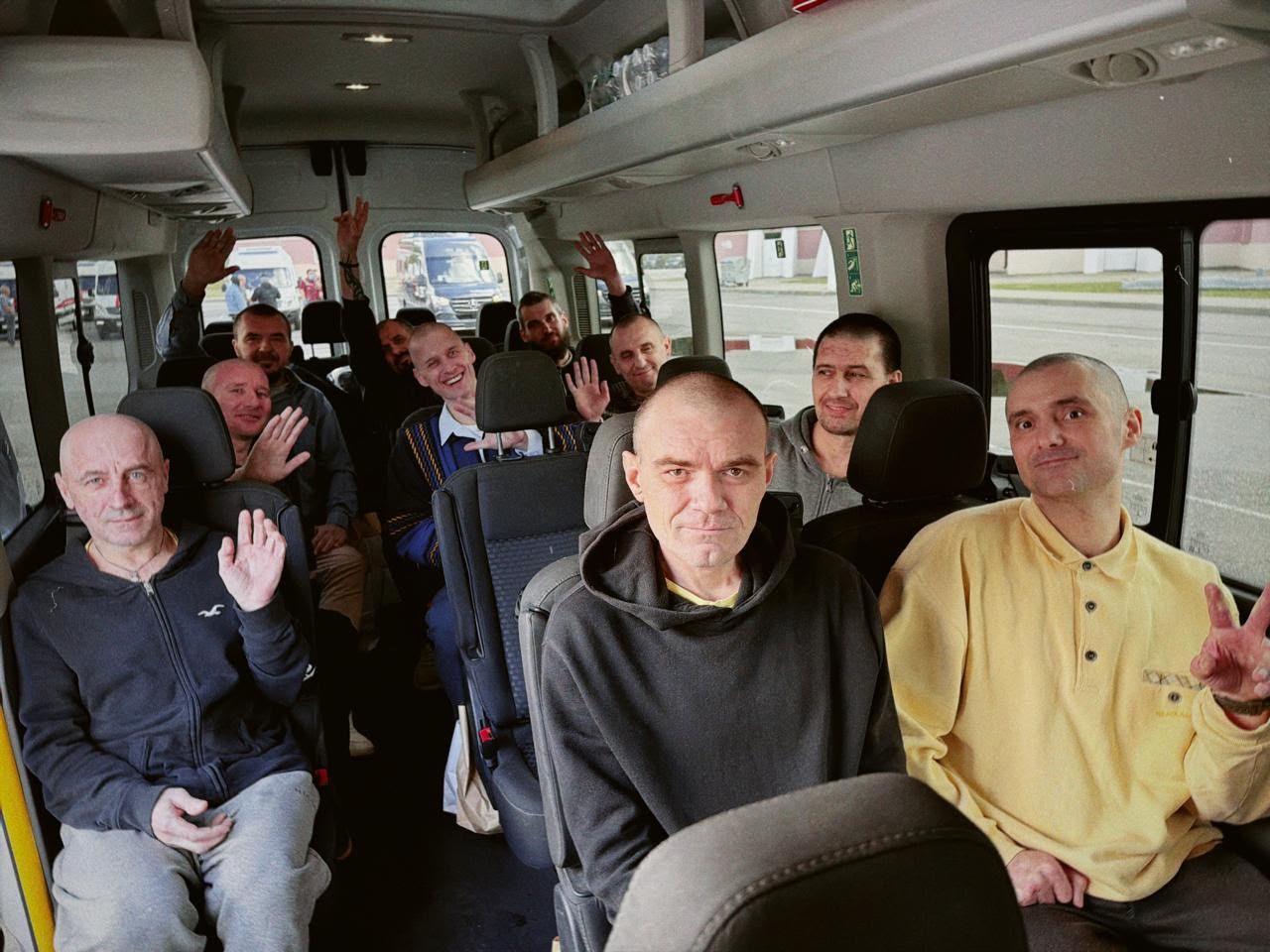 У межах спеціального етапу обміну, здійсненого через територію Білорусі 24 серпня, додому повернулися 10 українських захисників із лав ЗСУ та Нацгвардії, які вважалися зниклими безвісти на Донецькому напрямку. На фото звільнені військовослужбовці перебувають у салоні пасажирського мікроавтобуса, вони посміхаються, показують патріотичні жести та махають руками, розділяючи спільну радість від довгоочікуваного повернення на рідну землю.