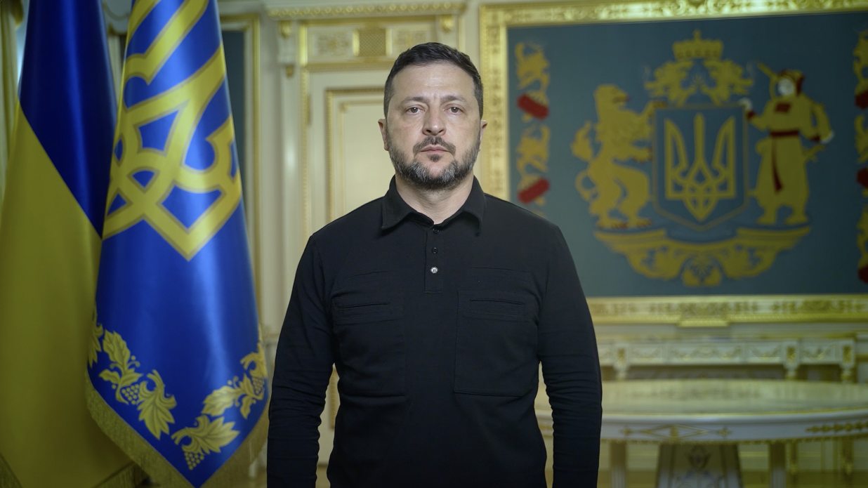 Офіційне відеозвернення Президента України Володимира Зеленського щодо наслідків розв’язаної Росією війни та де-факто закриття російського неба. Голова держави у чорній мілітарі-сорочці стоїть по центру кадру із зосередженим виразом обличчя. Ліворуч позаду нього встановлено державний прапор та синій штандарт Президента із золотим тризубом. Праворуч на стіні в золотій рамі зображено великий Державний Герб України з левом та козаком. Офіційне звернення записане у світлому кабінеті з класичним позолоченим інтер'єром.