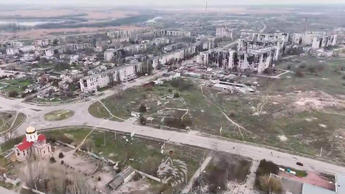 Панорамний знімок з дрона від 34-ї окремої бригади морської піхоти «Борисфен» фіксує масштабні руйнування міської забудови в Олешках, що ілюструє заяву глави МЗС Андрія Сибіги про створену РФ гуманітарну катастрофу на окупованому лівобережжі Херсонщини. У правій частині кадру видно багатоповерхові житлові будинки, які сильно обгоріли, мають зруйновані стіни та випалені віконні прорізи внаслідок ворожих обстрілів. На передньому плані ліворуч на тлі спорожнілих вулиць та пустирів розташована церква з червоним дахом і золотим куполом біля кільцевої дорожньої розв'язки, а на дальньому плані під похмурим небом видніється рівнинний пейзаж із руслом річки, що підкреслює наслідки окупації, за які Росія має нести повну відповідальність на міжнародній арені.