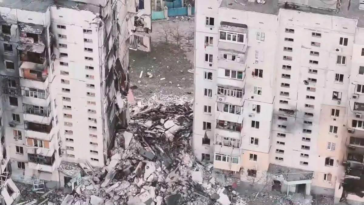 Знімок з дрона з близької відстані зафіксував наслідки тотального руйнування міжповерхових секцій у багатоповерховому житловому будинку в Олешках, що ілюструє заяву глави МЗС Андрія Сибіги про створену РФ гуманітарну катастрофу на окупованому лівобережжі Херсонщини. Центральний під'їзд між двома великими панельними дев'ятиповерхівками повністю обвалився від верхнього до першого поверху, перетворившись на величезну купу з уламків бетонних плит, арматури та сміття. Лівий корпус споруди сильно обгорів та має випалені балкони через ворожі обстріли, а торцева стіна правого корпусу повністю оголила внутрішні конструкції знищених кімнат, що підкреслює критичні масштаби руйнувань цивільної інфраструктури, за які Росія має нести відповідальність на міжнародній арені та під час засідань Генеральної Асамблеї ООН.