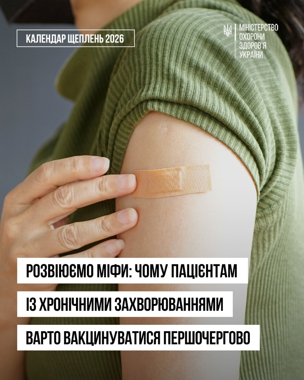 Офіційний інформаційний банер Міністерства охорони здоров'я України про важливість першочергової вакцинації людей із хронічними хворобами на тлі роз'яснення медичних показань щодо захисту вразливого імунітету. На фото пацієнт у зеленій трикотажній кофті притискає пальцями свіжий бежевий медичний пластир, наклеєний на плече одразу після щеплення. У верхній частині розміщено логотип установи та напис «КАЛЕНДАР ЩЕПЛЕНЬ 2026», а внизу на білих плашках нанесено великий чорний заголовок «РОЗВІЮЄМО МІФИ: ЧОМУ ПАЦІЄНТАМ ІЗ ХРОНІЧНИМИ ЗАХВОРЮВАННЯМИ ВАРТО ВАКЦИНУВАТИСЯ ПЕРШОЧЕРГОВО», що застерігає про небезпеку інфекцій при діабеті, астмі чи серцевих патологіях. Текст релізу наголошує на важливості обов'язкових і рекомендованих щеплень від грипу, пневмокока та гепатитів для пацієнтів із хронічним перебігом хвороб, вибір яких після консультації лікаря допомагає запобігти госпіталізації.