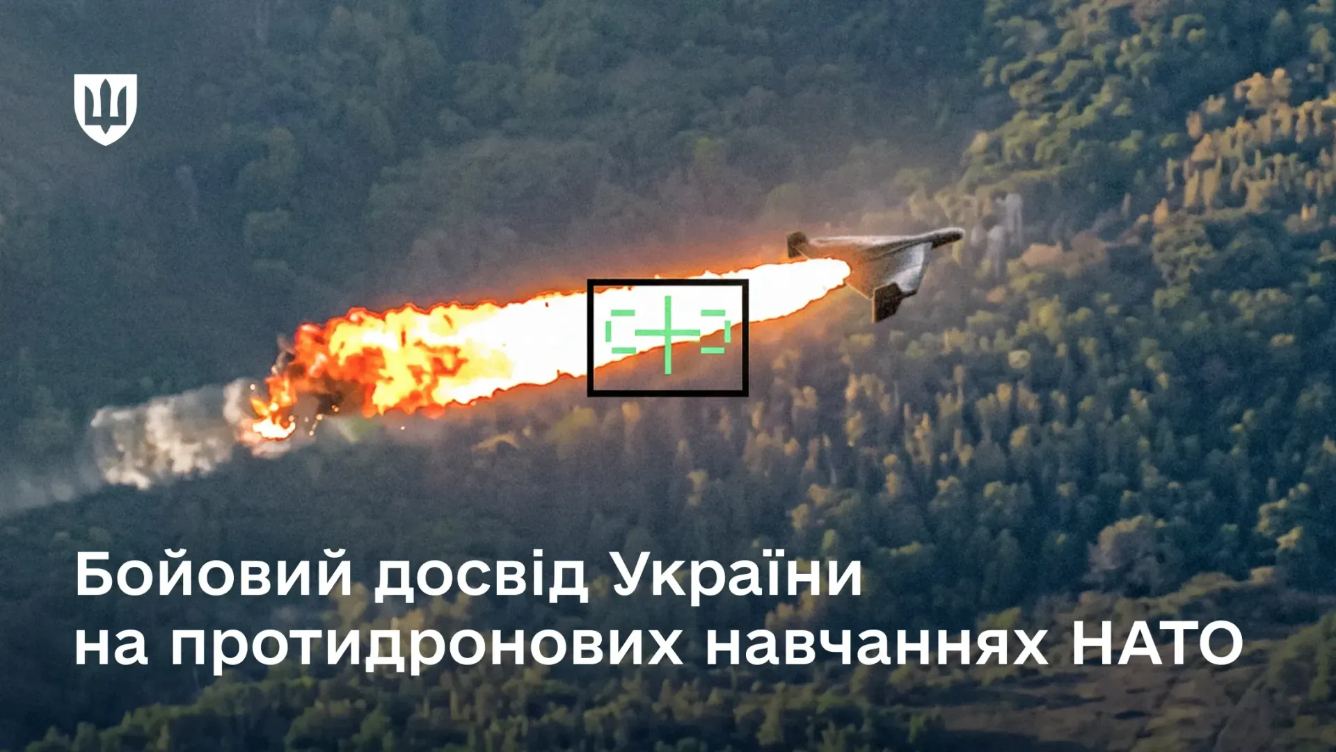 Офіційний інформаційний банер із заголовком про участь Сил оборони України у протидронових навчаннях НАТО, на якому зображено момент ураження ударного безпілотника типу «Шахед» у межах навчань «LCI-X 3-26 Execution» у Латвії. На тлі густого лісового масиву зафіксовано політ БпЛА, який узятий у квадратну рамку прицілу з зеленим перехрестям, а позаду нього тягнеться довгий вогняний шлейф із вибухом. У лівому верхньому кутку банера розміщено білий логотип у вигляді Малого Державного Герба України, а внизу нанесено великий напис: «Бойовий досвід України на протидронових навчаннях НАТО». Кадр ілюструє результати етапу навчань Exercise Baltic Trust за участю понад 1 000 військових із 25 країн Альянсу, під час якого українські експерти Спільного центру JATEC коригували сценарії під реалії фронту, контролювали дії умовного противника та допомагали інтегрувати багатоелементні рішення протидронової боротьби в системи командування та управління НАТО.