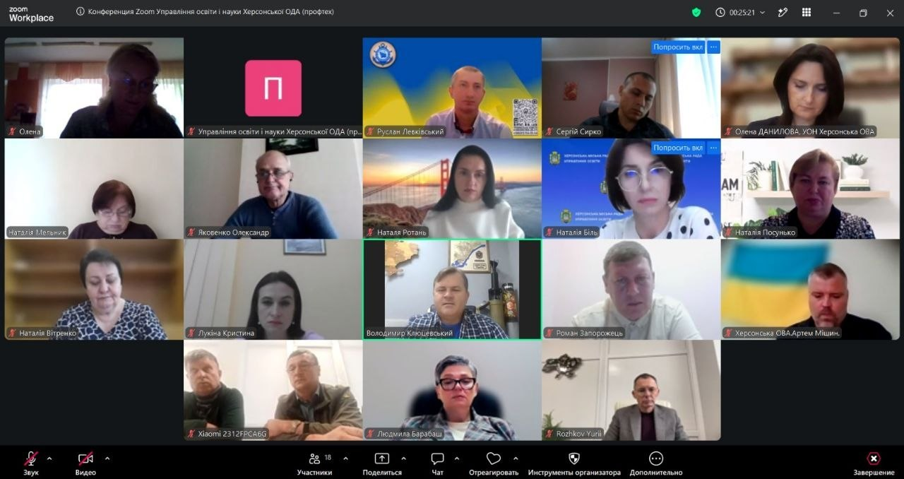 На екрані в інтерфейсі Zoom Workplace відображається розширена галерея учасників онлайн-засідання регіональної ради професійної освіти при Херсонській ОВА, де чітко видно розташування кожного посадовця у віконцях відеодзвінка. У першому ряду в крайньому правому віконці сидить начальник управління освіти і науки Херсонської ОДА Олена Данилова. У другому ряду в крайньому правому віконці в окулярах знаходиться начальниця управління освіти Херсонської міської ради Наталія Біль. У третьому ряду ліворуч зафіксована директор Департаменту фінансів Херсонської ОДА Наталія Вітренко, по центру цього ж ряду сидить заступник голови Херсонської ОДА Володимир Клюцевський, а праворуч на тлі прапора України — директор Департаменту розвитку економіки ХОДА Артем Мішин. У четвертому ряду в крайньому правому віконці працює комерційний директор ПП «Оригінал Авто» Юрій Рожков. Кадр ілюструє спільну координацію влади, підприємців та освітян, під час якої учасники обговорили впровадження дуальної освіти, міжнародну практику для курсантів ХДМА та реалізацію програм Skills4Recovery для ПТУ задля підготовки кадрів для майбутньої відбудови регіону.