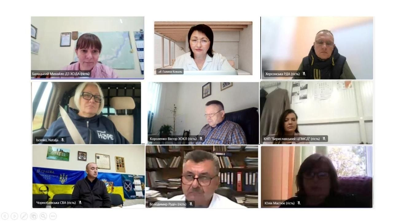 На екрані в інтерфейсі онлайн-платформи відображається робоче засідання Регіональної ради з питань протидії туберкульозу, наркоманії та ВІЛ-інфекції/СНІДу при Херсонській ОВА, де у дев'яти віконцях відеодзвінка зафіксовано медичних фахівців та представників прифронтових громад. У першому ряду ліворуч у віконці з підписом Балацький Михайло ДЗ ХОДА відображається директорка Департаменту здоров’я Херсонської ОВА Тетяна Карчевич, по центру розташована Галина Коваль, а праворуч — представник Херсонської РДА. У другому ряду ліворуч у фірмовому худі «HOPE» сидить Наталія Іщенко, по центру — генеральний директор Херсонської обласної клінічної лікарні Віктор Короленко, а праворуч — представник КНП «Бериславський ЦПМСД». У третьому ряду ліворуч на тлі Державного Прапора України сидить представник Чорнобаївської СВА, по центру — Володимир Рудіч, а праворуч — Юлія Мастюк. Кадр ілюструє нараду під головуванням Тетяни Карчевич, під час якої учасники проаналізували виконання програм у Чорнобаївській громаді, роботу БО «Позитивні жінки» та опрацювали Регіональний план відновлення медичних послуг із протидії ВІЛ та туберкульозу на 2026–2027 роки в умовах воєнного стану.