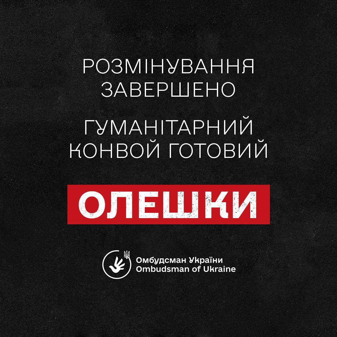 Інформаційне повідомлення Офісу Уповноваженого Верховної Ради України з прав людини (Омбудсмана України) про готовність до початку гуманітарної операції в тимчасово окупованому місті Олешки Херсонської області. Зображення виконане у вигляді лаконічної офіційної плашки на текстурованому темно-сірому або чорному тлі. У центрі банера великими білими літерами нанесено чіткий трирядковий текст: «РОЗМІНУВАННЯ ЗАВЕРШЕНО», «ГУМАНІТАРНИЙ КОНВОЙ ГОТОВИЙ» та нижче слово «ОЛЕШКИ», яке додатково виділене яскравим горизонтальним прямокутником червоного кольору. У нижній частині по центру розміщено круглий білий офіційний логотип Омбудсмана України із зображенням стилізованого тризуба та розкритої долоні, поруч із яким двома мовами нанесено підписи: «Омбудсман України» та «Ombudsman of Ukraine».