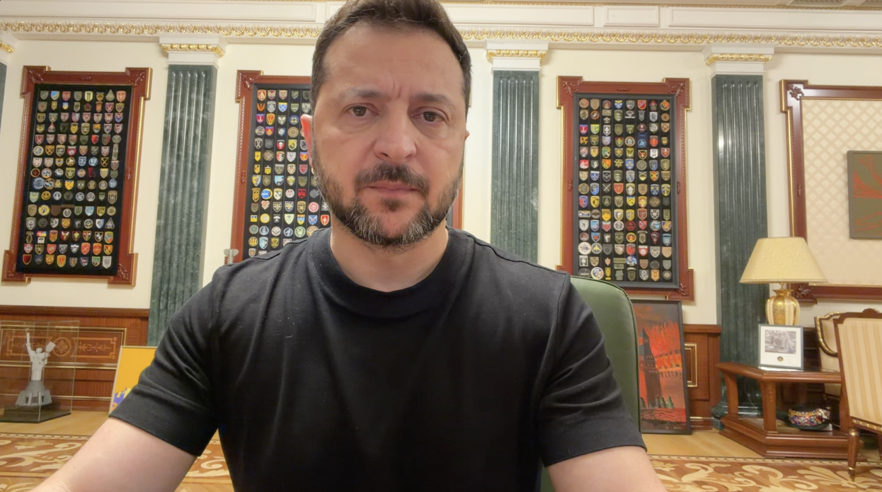 Тема загрози нових російських балістичних ударів, протидії ворожому терору та заклику до партнерів щодо посилення ППО і санкційного тиску стала ключовою у вечірньому відеозверненні, під час якого Президент України Володимир Зеленський у чорній футболці зображений крупним планом на тлі офіційного кабінету Офісу Президента. Голова держави сидить у кріслі перед камерою на тлі стіни з декоративними колонами, де позаду нього на дерев'яних панелях розвішані великі вертикальні стенди з чисельними шевронами та військовими емблемами підрозділів Сил оборони України. Праворуч на задньому плані видно картину у рамці з патріотичним сюжетом у вогняних тонах, настільну лампу зі світлим абажуром на столику та частину меблів кабінету, а ліворуч — невеликий макет монумента «Батьківщина-мати».