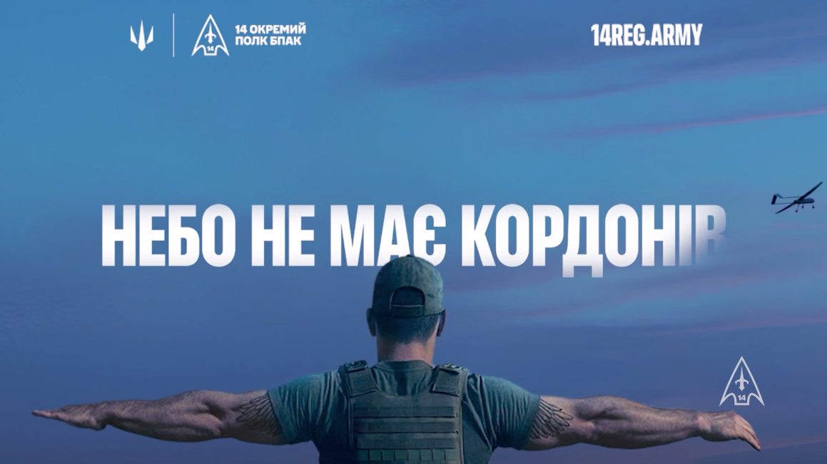 Військовий у спорядженні стоїть спиною до глядача, розправивши руки на фоні вечірнього неба з безпілотником. По центру напис «НЕБО НЕ МАЄ КОРДОНІВ», зверху — символіка 14-го окремого полку БпАК.