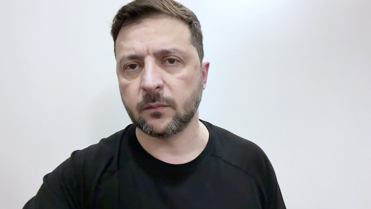 Крупний план обличчя чоловіка середнього віку на тлі білої стіни, він одягнений у чорну футболку.