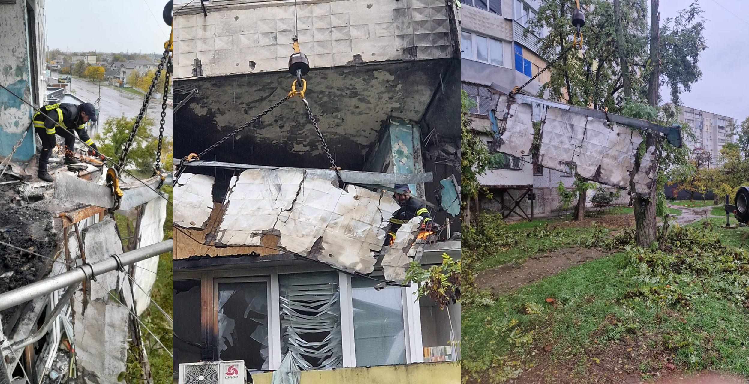 Зображення-триптих, що фіксує процес демонтажу або видалення великої, пошкодженої частини житлового будинку, ймовірно, після обстрілу.  Ліва і центральна частини: Показують рятувальників або робітників (ймовірно, у формі ДСНС або комунальних служб) у процесі роботи. Велика, зруйнована панель фасаду (можливо, балконна плита або частина стіни) підвішена на металевих ланцюгах і гаках, прикріплених до крана (якого не видно). Робітники перебувають на висоті поруч із цим уламком і закріплюють його або контролюють спуск. Внизу видно розбиті вікна та сліди обгорання.  Права частина: Показує цей же великий уламок, який вже лежить на землі, приземлився серед дерев і ґрунту біля житлового будинку на задньому плані. Це підтверджує процес демонтажу небезпечних конструкцій.