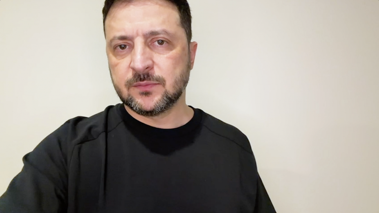 Портретне фото чоловіка середнього віку з короткою бородою та сивиною, одягненого в чорну спортивну кофту. Він дивиться прямо в камеру на фоні світлої однотонної стіни.