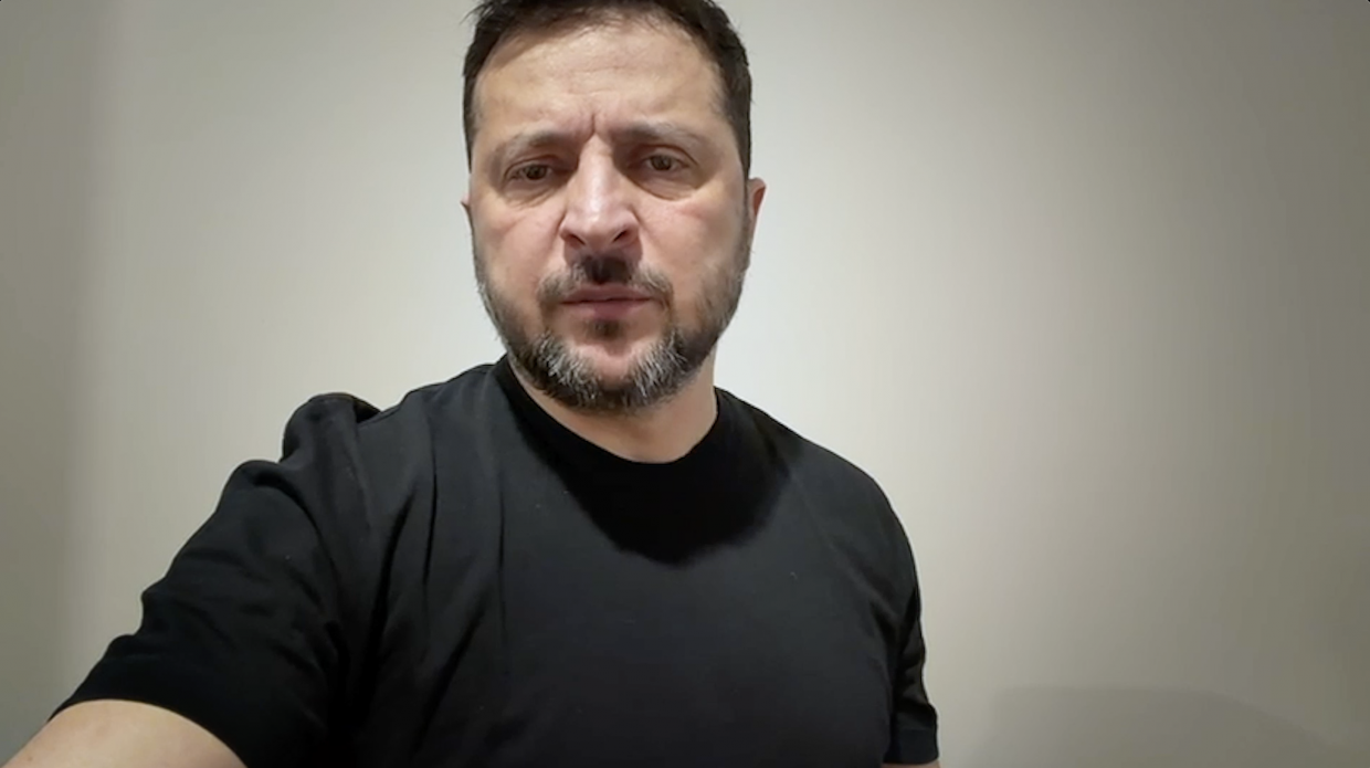 Портрет чоловіка з короткою бородою, одягненого в чорну футболку, на світлому нейтральному фоні. Чоловік дивиться прямо в камеру з серйозним виразом обличчя.