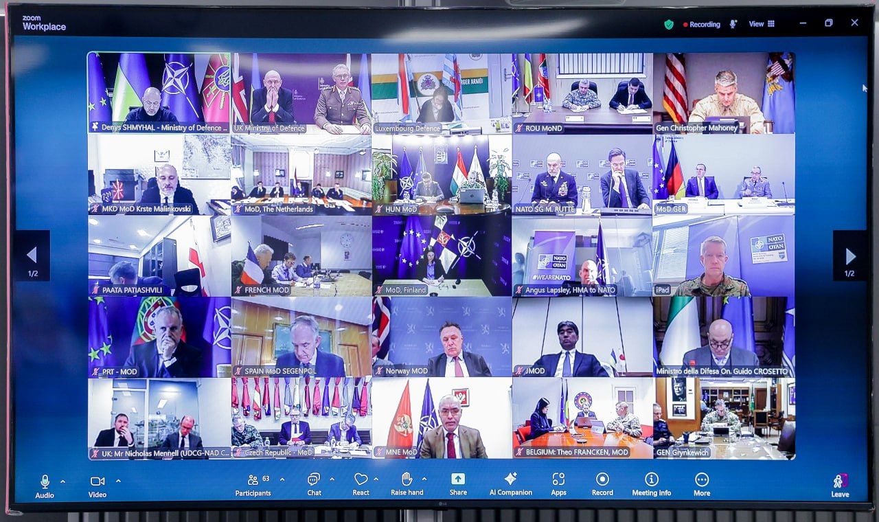 Знімок екрана монітора під час міжнародної відеоконференції у форматі Zoom. На екрані відображено сітку з понад 20 вікнами учасників, серед яких представники оборонних відомств різних країн та НАТО. У верхньому лівому куті видно офіційного представника України на фоні державних та військових прапорів.