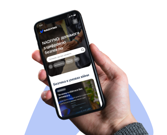 Знімок екрана мобільного застосунку «NADIYNO» на смартфоні, який тримає рука. На екрані відображено заголовок: «NADIYNO: допомога з цифровою безпекою» та поле пошуку з текстом-заповнювачем «Питання, що вас цікавить». Нижче є теги: «Анонімність», «Пароль», «VPN». Також видно заголовок: «Безпека в умовах війни» та фрагмент статті: «Чи можу я обійтися без антивірусу?».