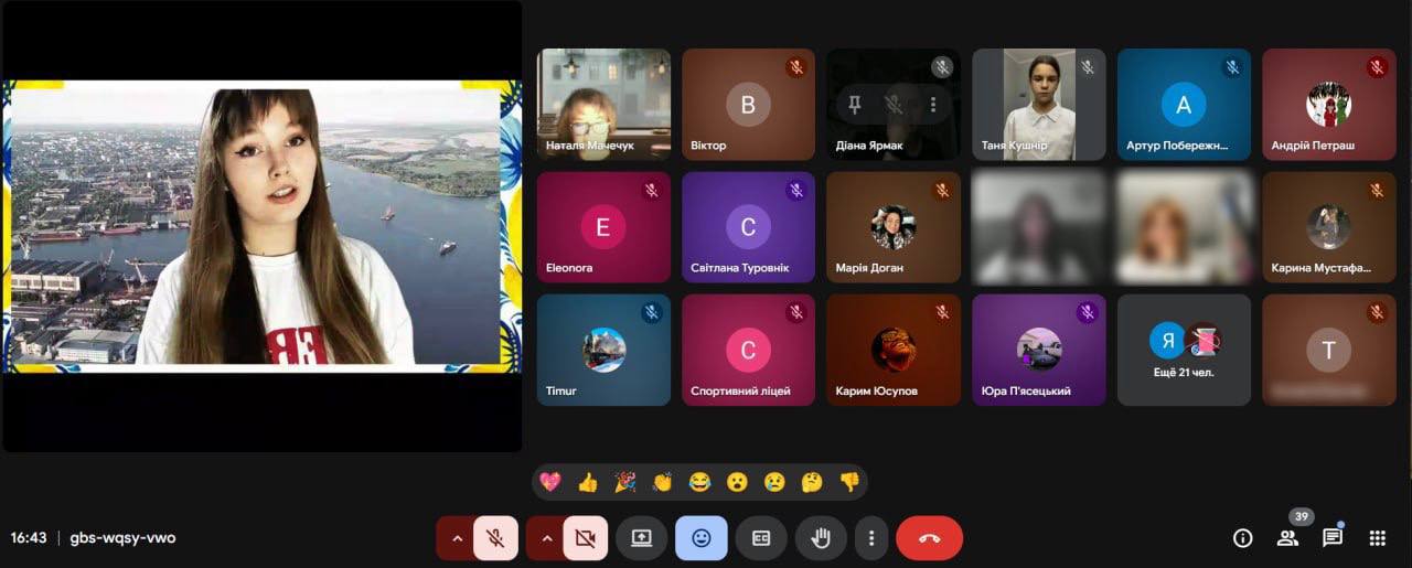 Скриншот екрана відеоконференції. На великому вікні зліва зображена молода жінка з довгим волоссям, яка виступає перед камерою, на тлі видно фотографію міста з портом. Праворуч розташована панель з вікнами інших учасників.